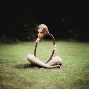 woman-holding-mirror-on-grass-reflection